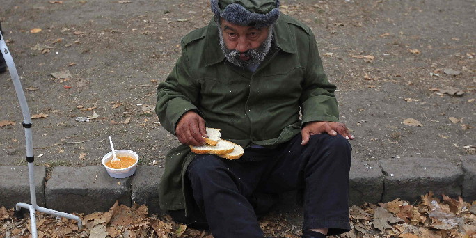 A man eats a free lunch received from Krishna followers in Budapest